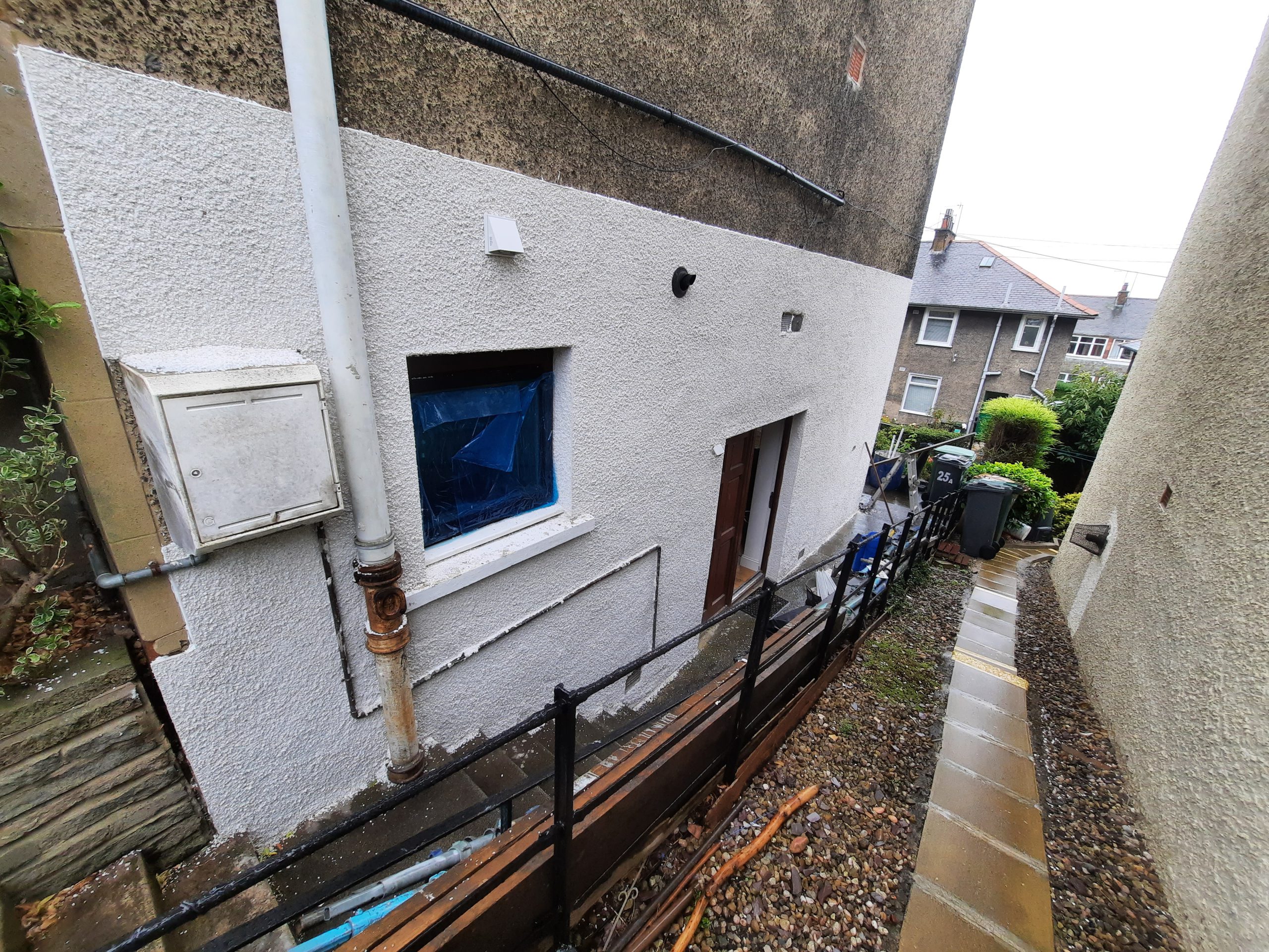 solid wall insulation Edinburgh on wall with blue-covered windows