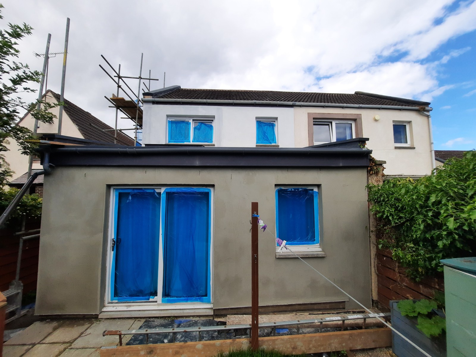 roughcasting Edinburgh on rear elevation with blue-protected patio doors