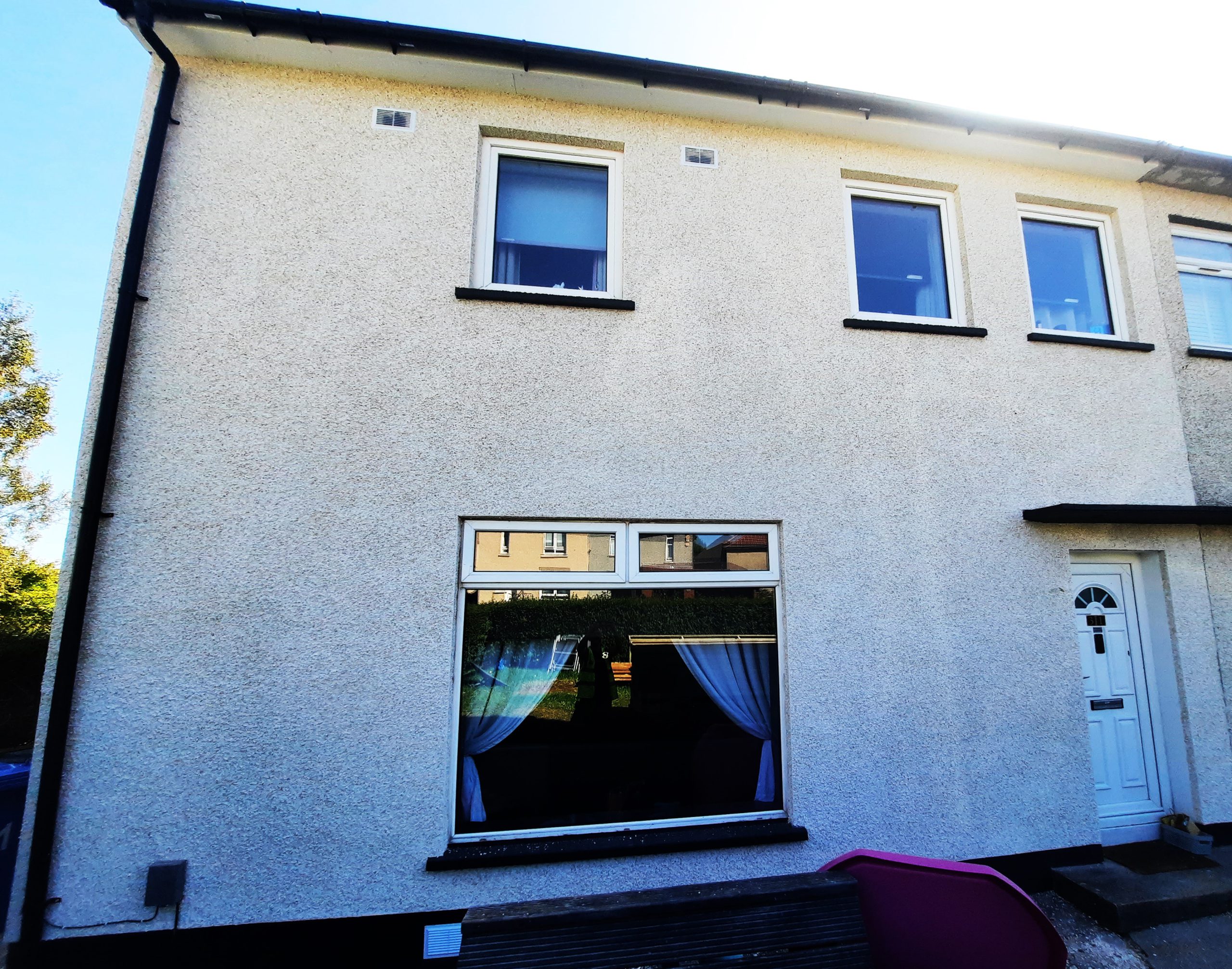roughcast render repair on rear wall with large window