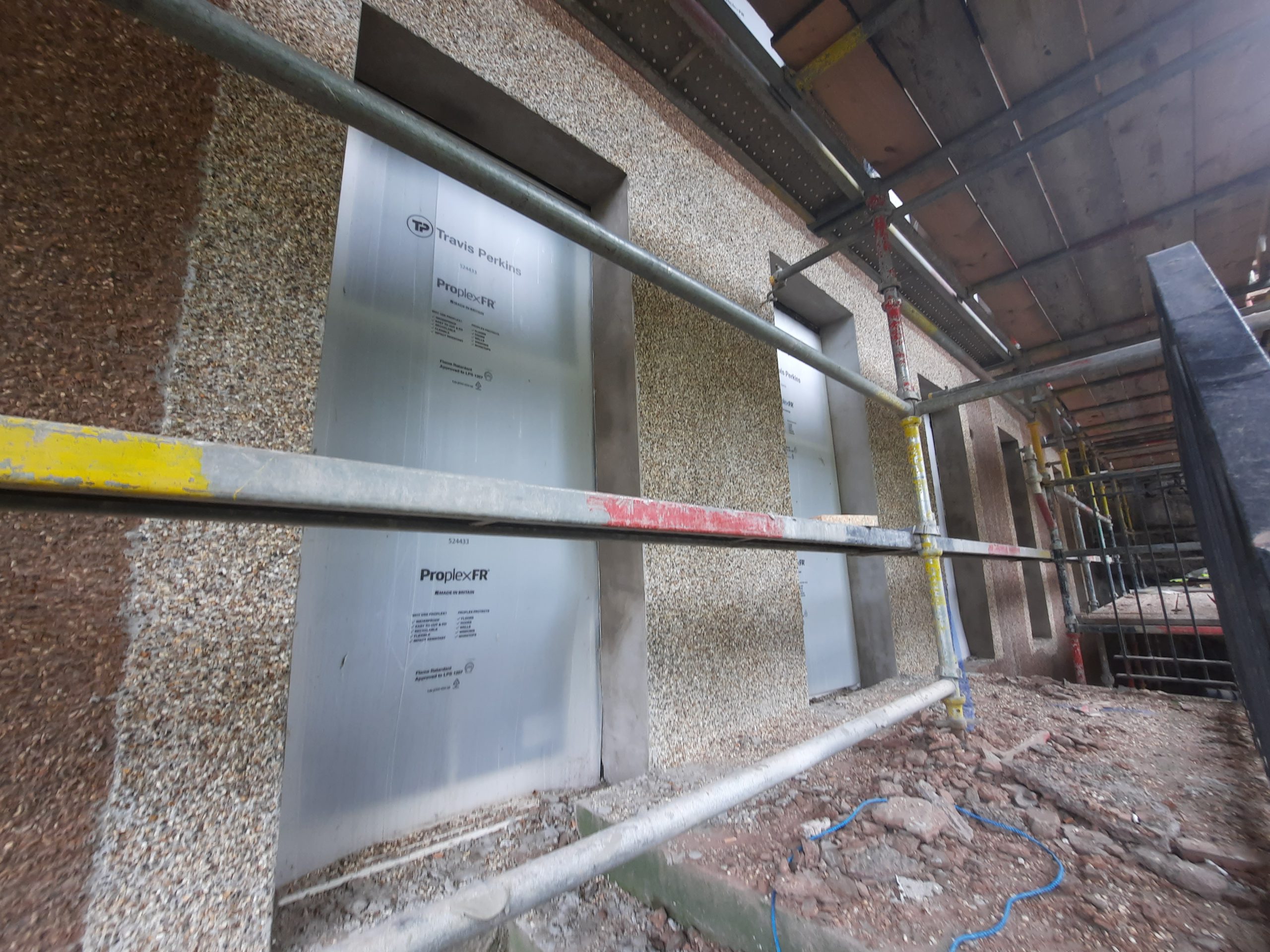 roughcast repair with insulation boards installed under scaffold
