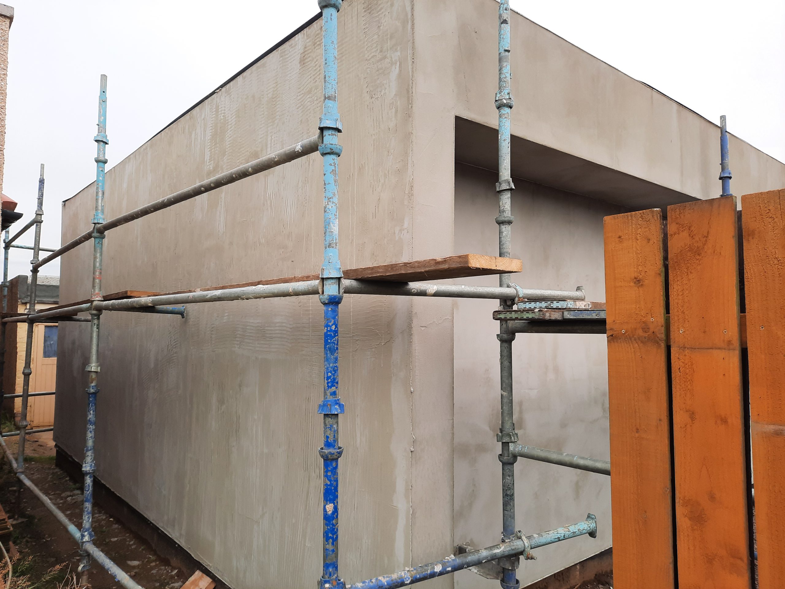 roughcaster Edinburgh working on modern flat-roof wall