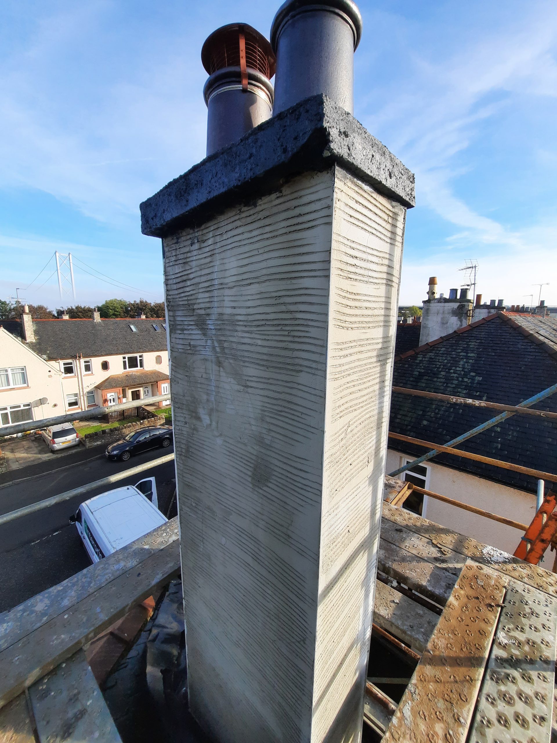 roughcast render repair on chimney stack with scaffolding