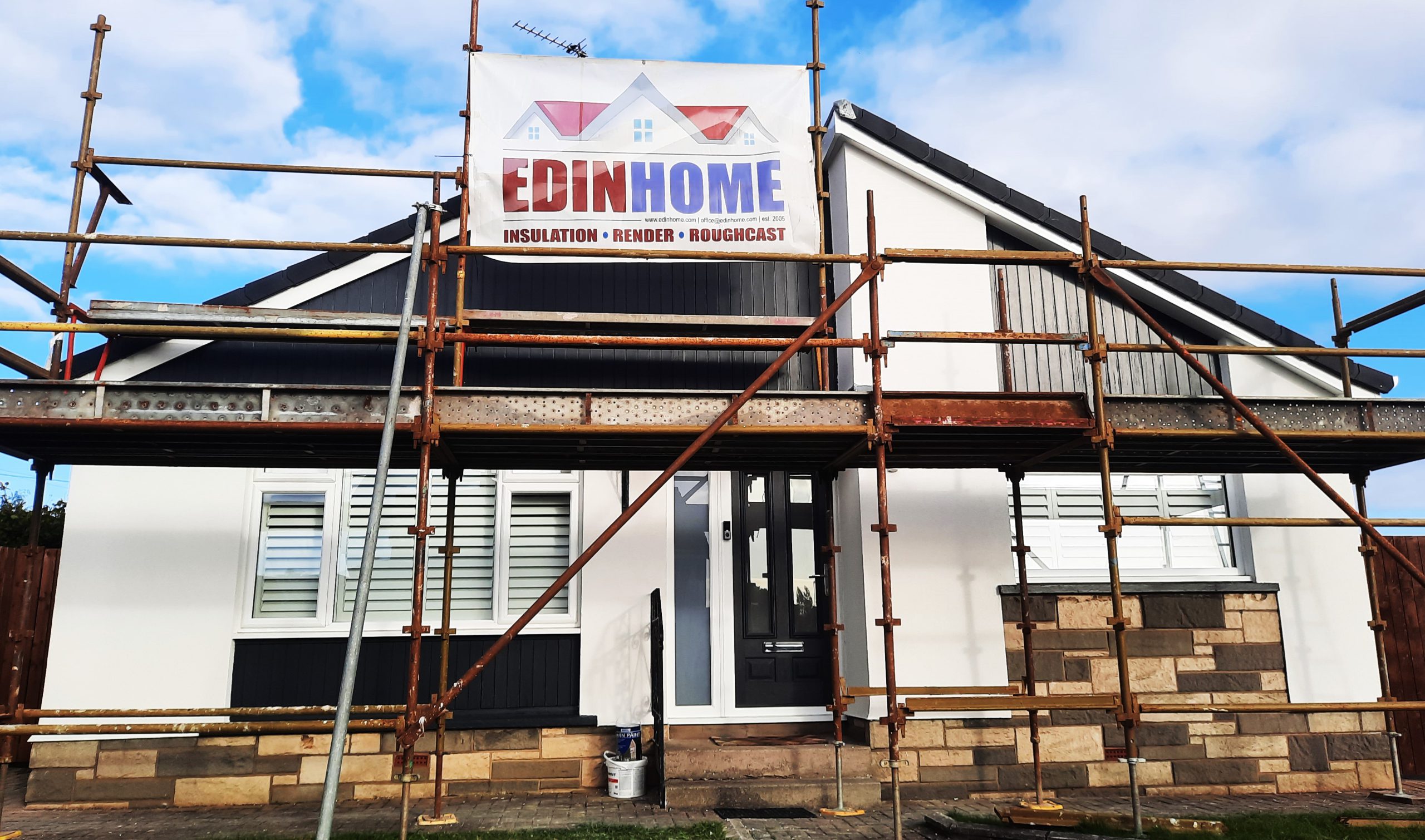 roughcast render repair on entrance façade under scaffolding