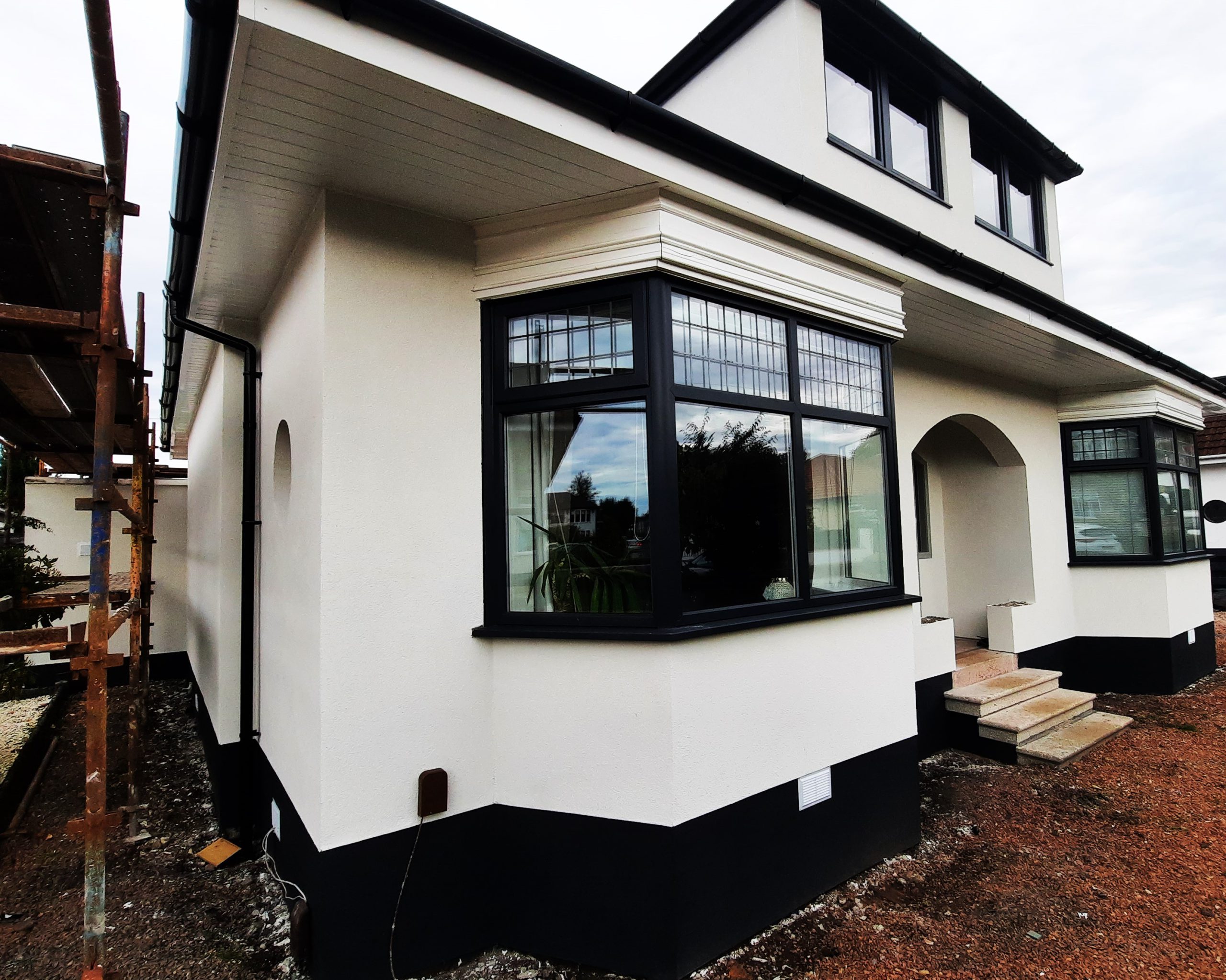 roughcasting Edinburgh on freshly rendered white house with black trim