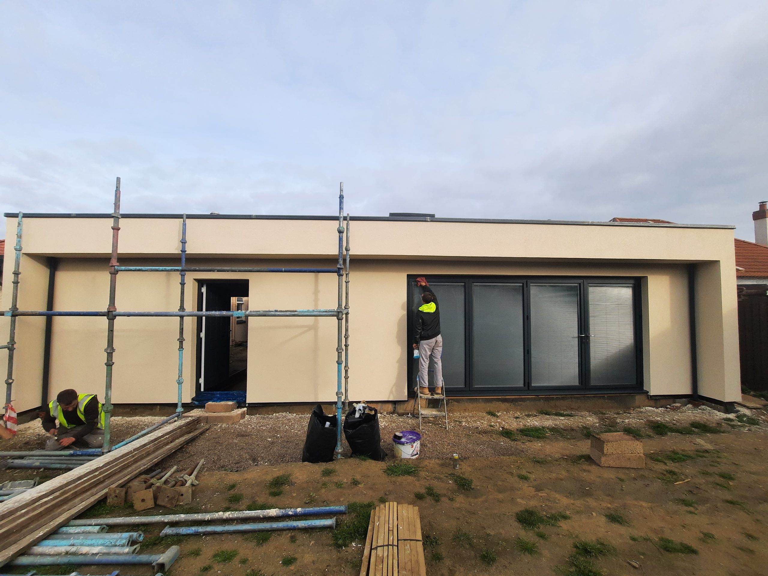 roughcast render repair on flat-roof modern façade