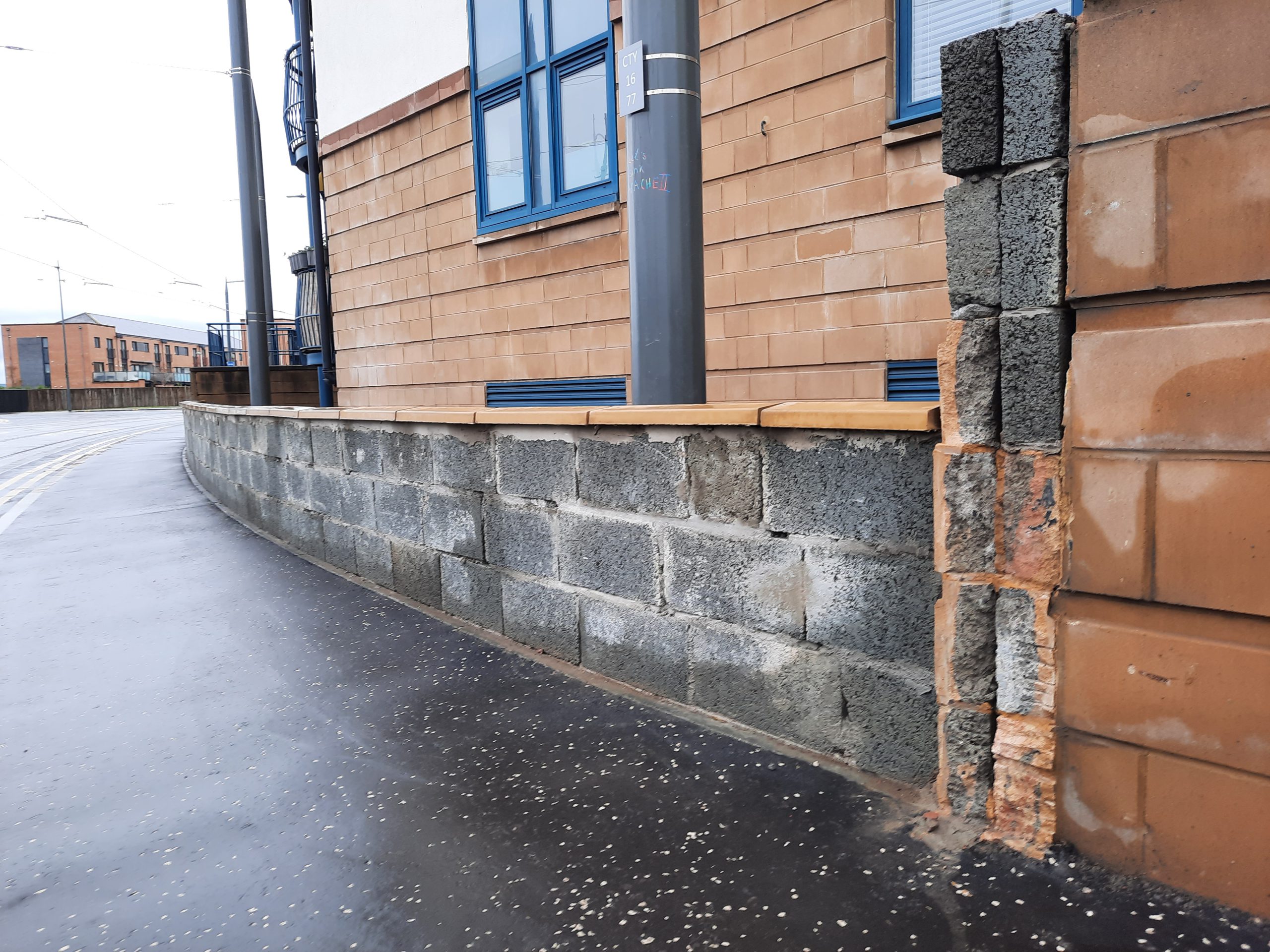 roughcast repair on commercial façade beside tram tracks