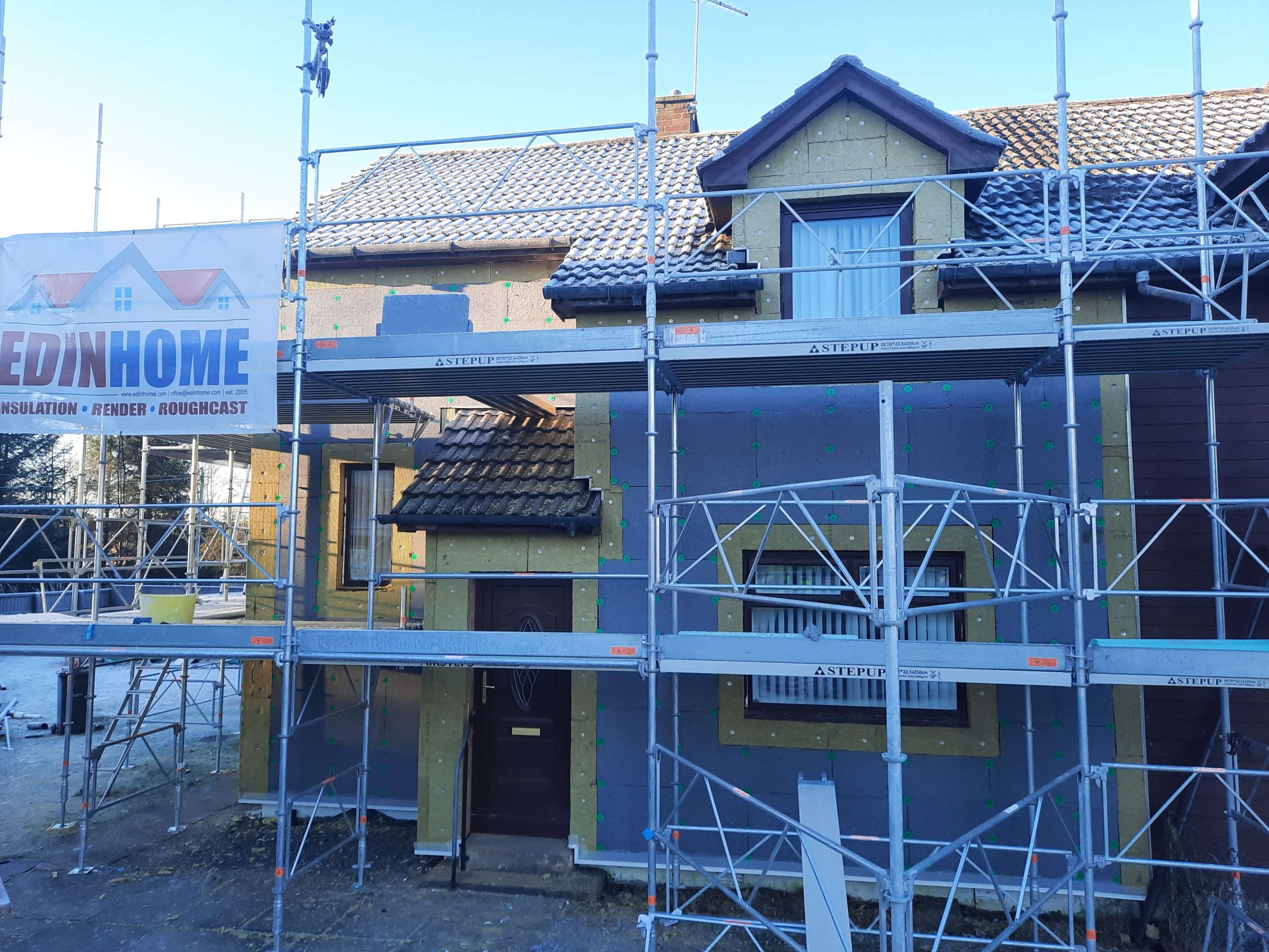 roughcast render repair on scaffolded entrance wall