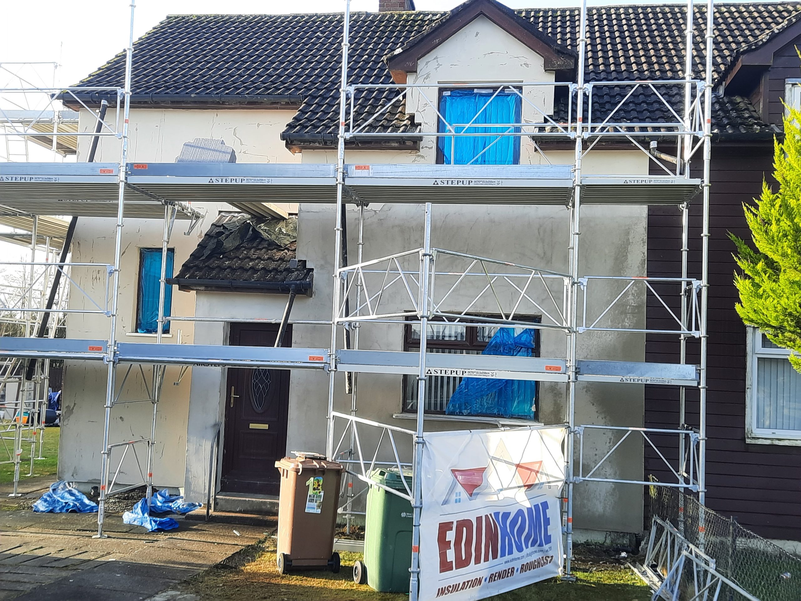 house rendering Edinburgh under renovation with blue window covers