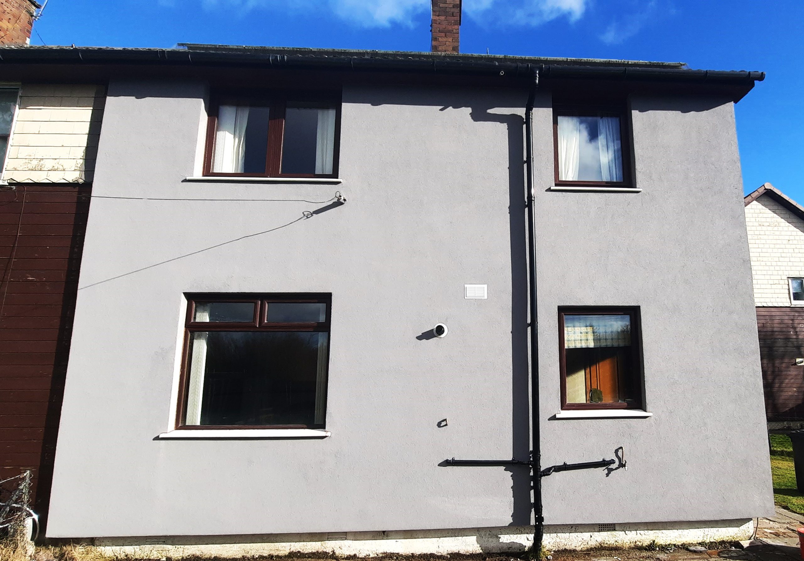 roughcast render repair on smooth grey rear wall