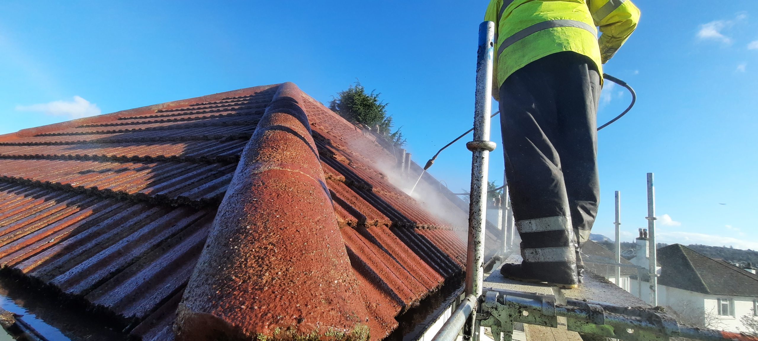 roughcast render repair along ridge tiles during power washing