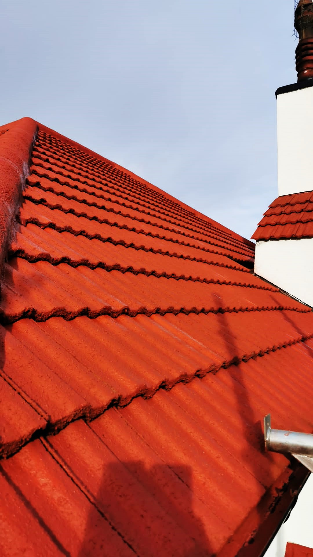 roughcast repair to gable end above bright red roof tiles