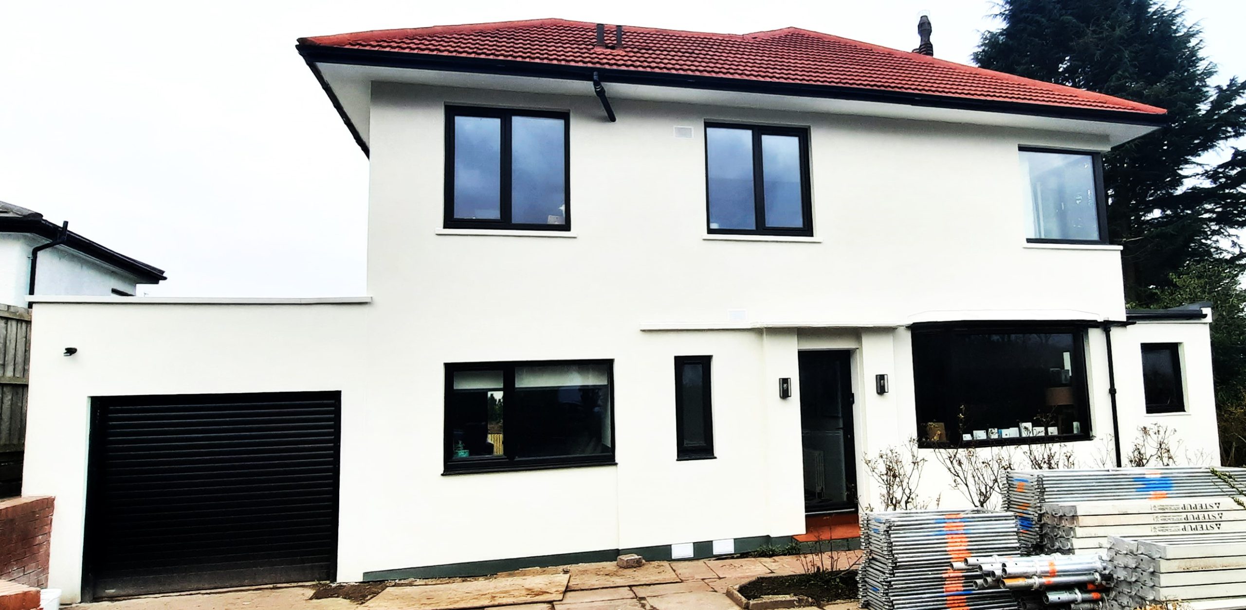 roughcast render repair on sleek white façade with red tiled roof