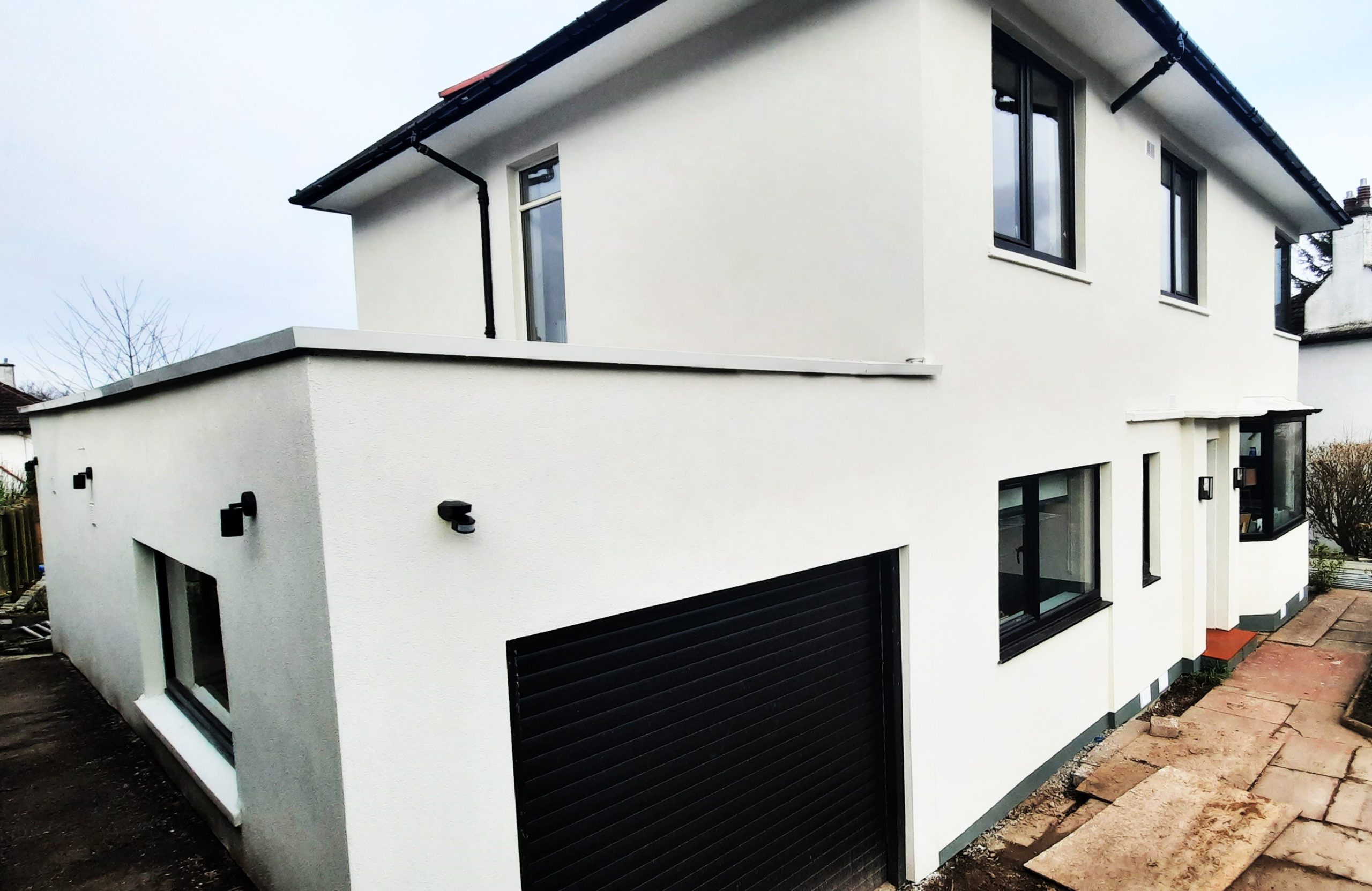 roughcast repair on gable wall beside black-framed windows