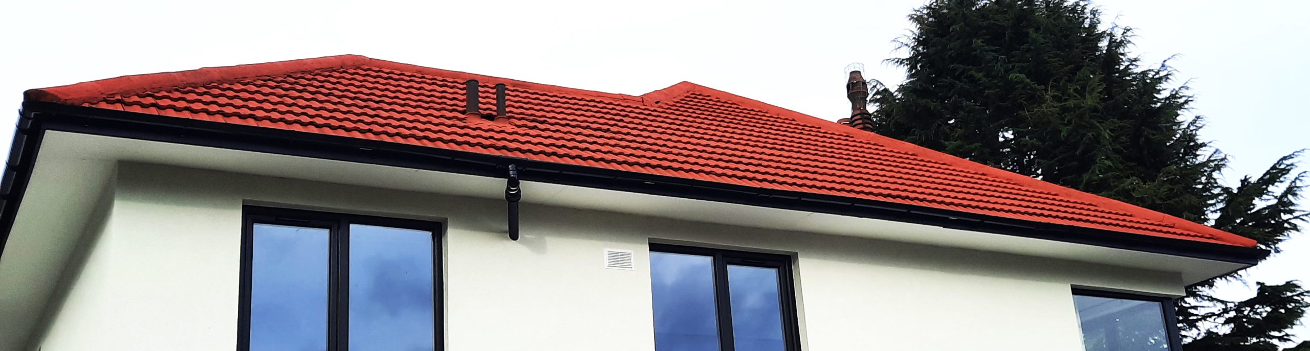 roughcast render repair under roof eaves above clean white wall