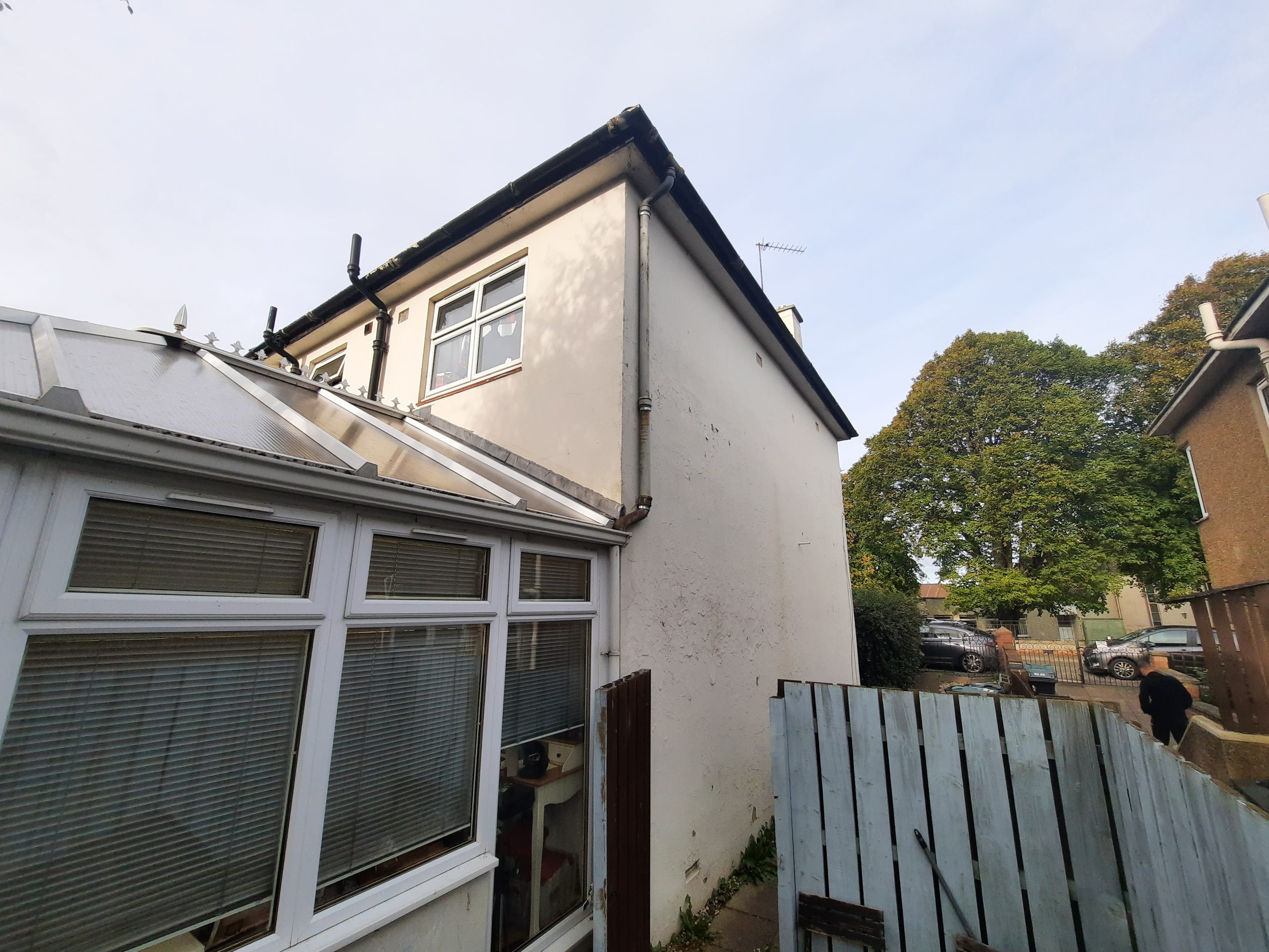 roughcast render repair on rear white elevation above conservatory