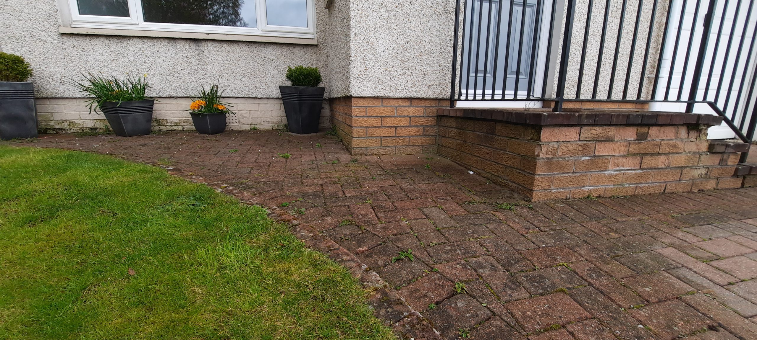 roughcast render repair on short retaining wall by driveway