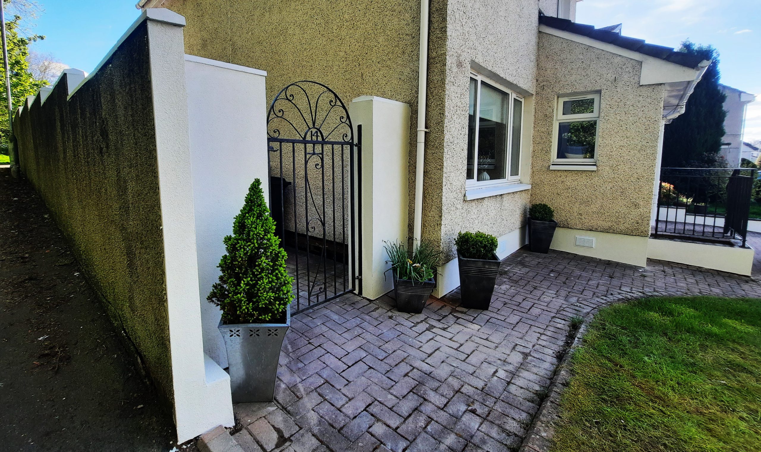 roughcast repair beside black wrought iron gate