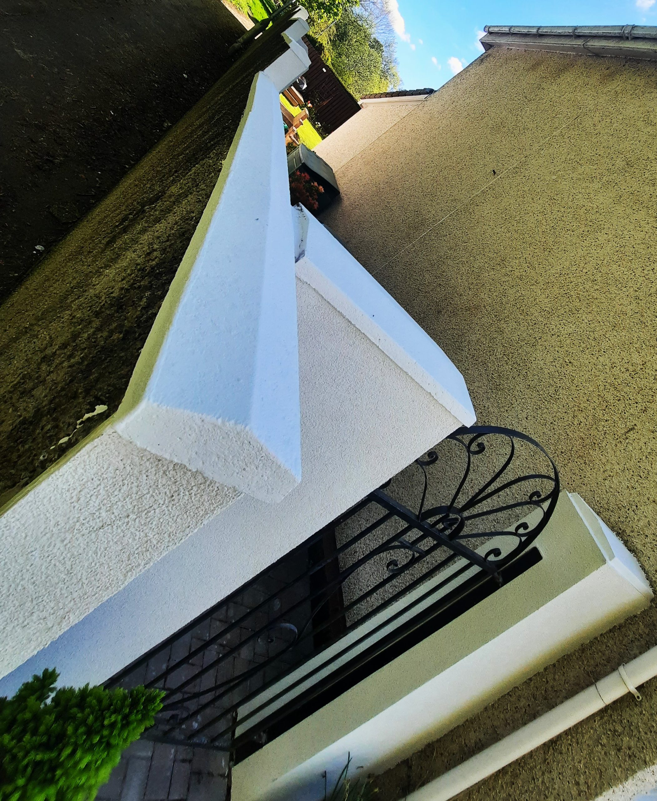 roughcast render repair on wall with decorative capstone