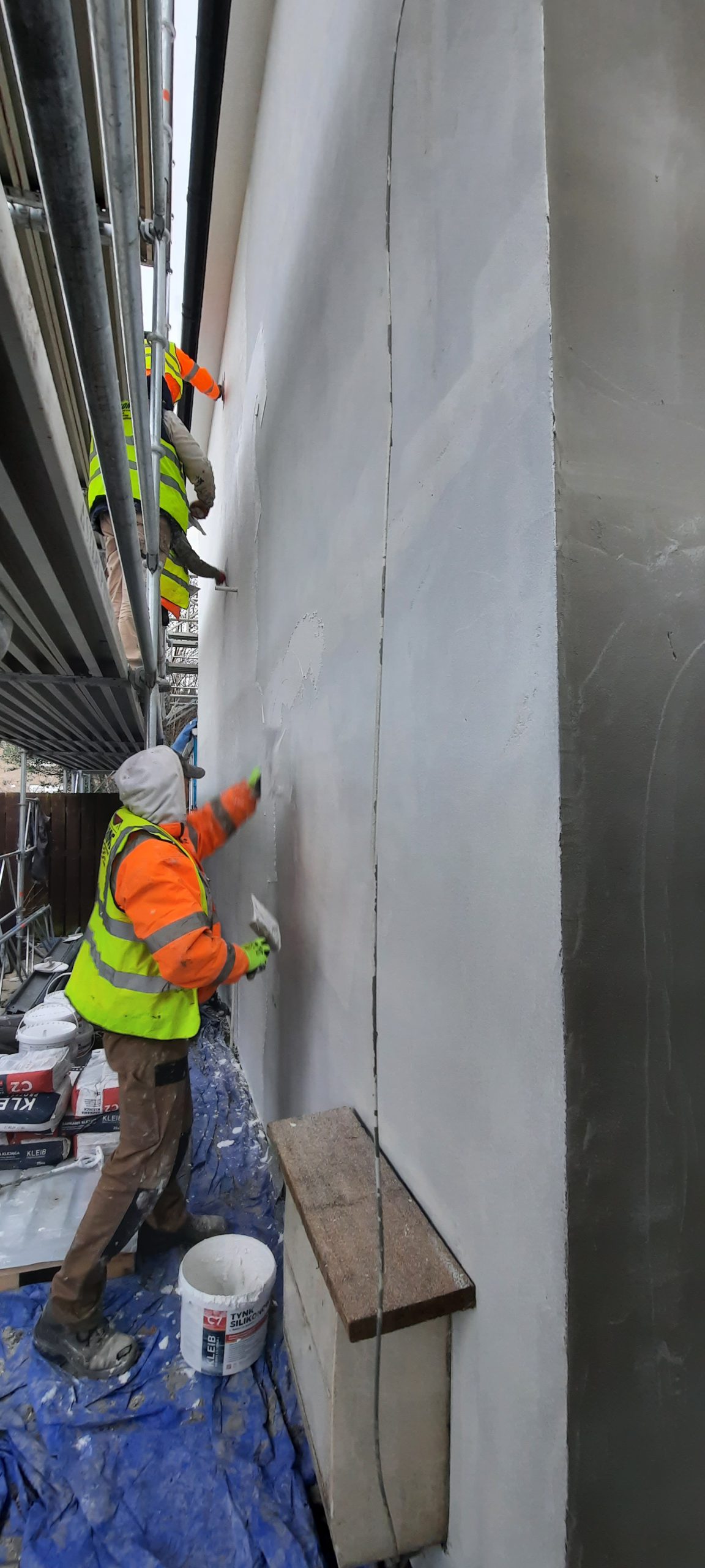 roughcasting Edinburgh applied by worker on scaffolded wall