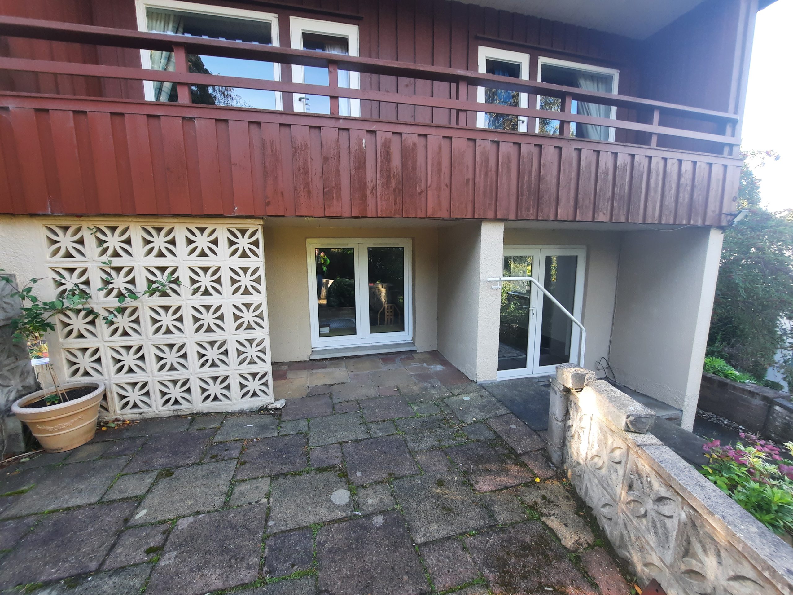 roughcast repair under timber-clad balcony structure