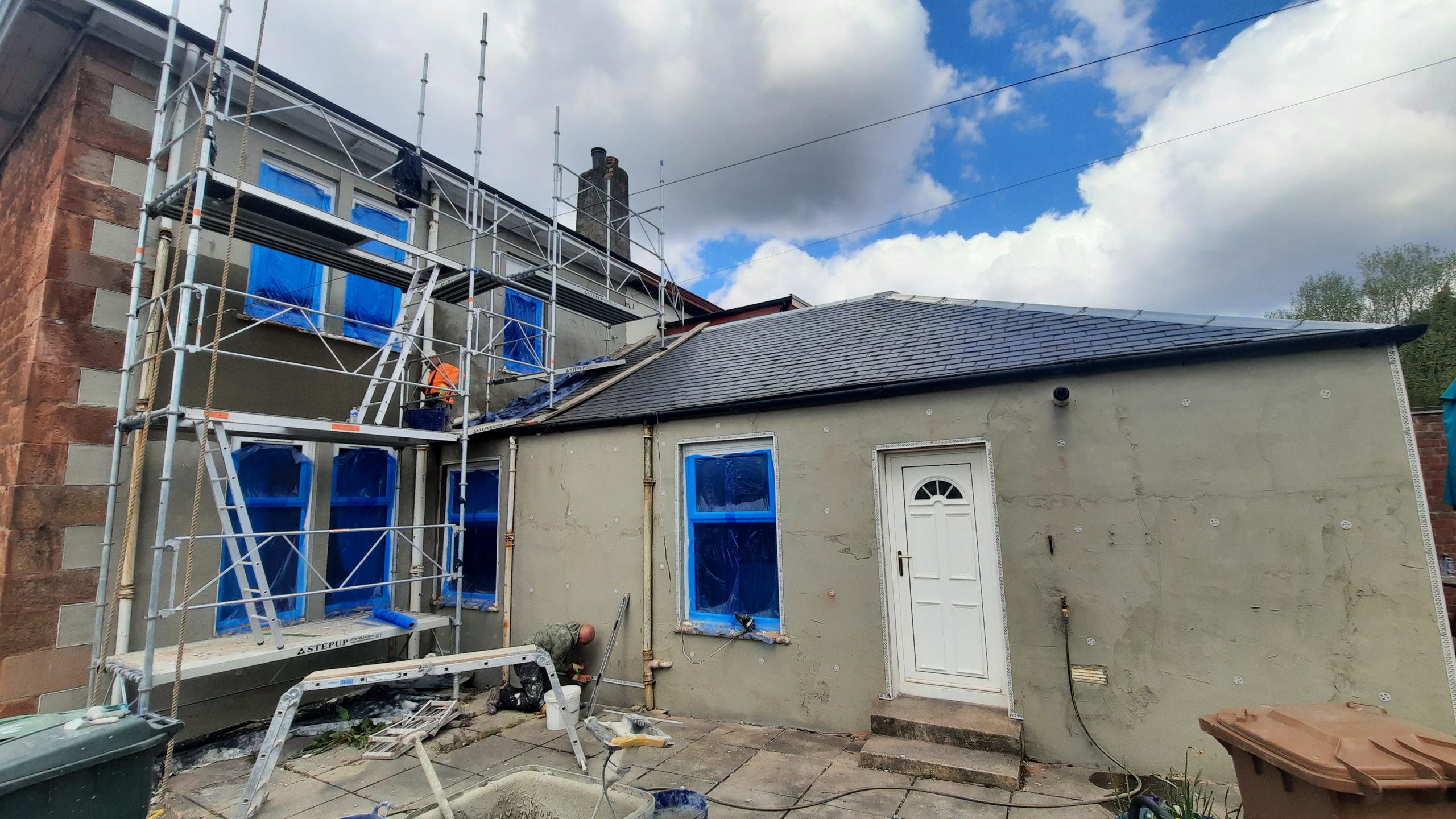 roughcast repair on rear wall with taped blue windows