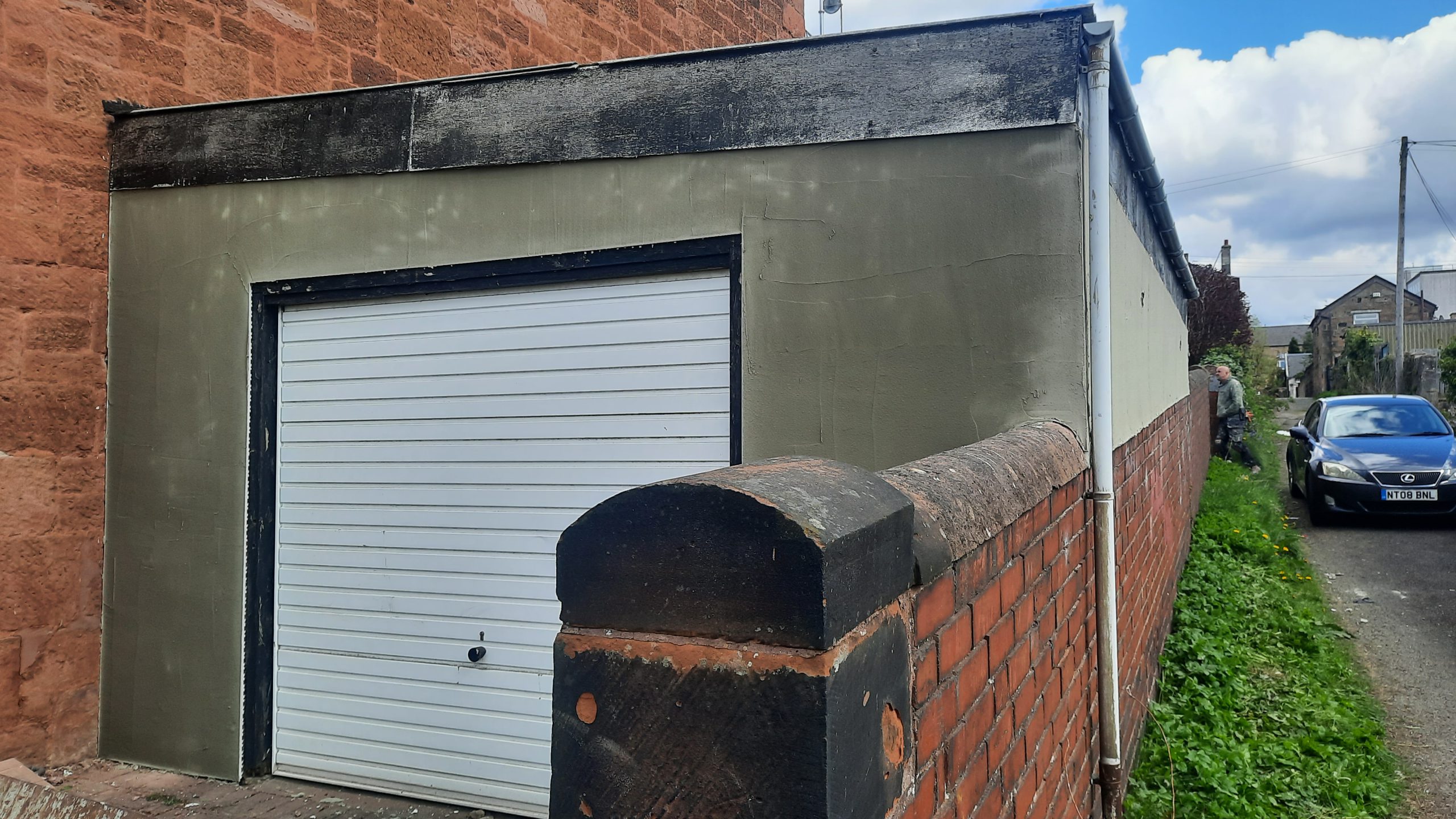 roughcast render Edinburgh repair above red brick wall