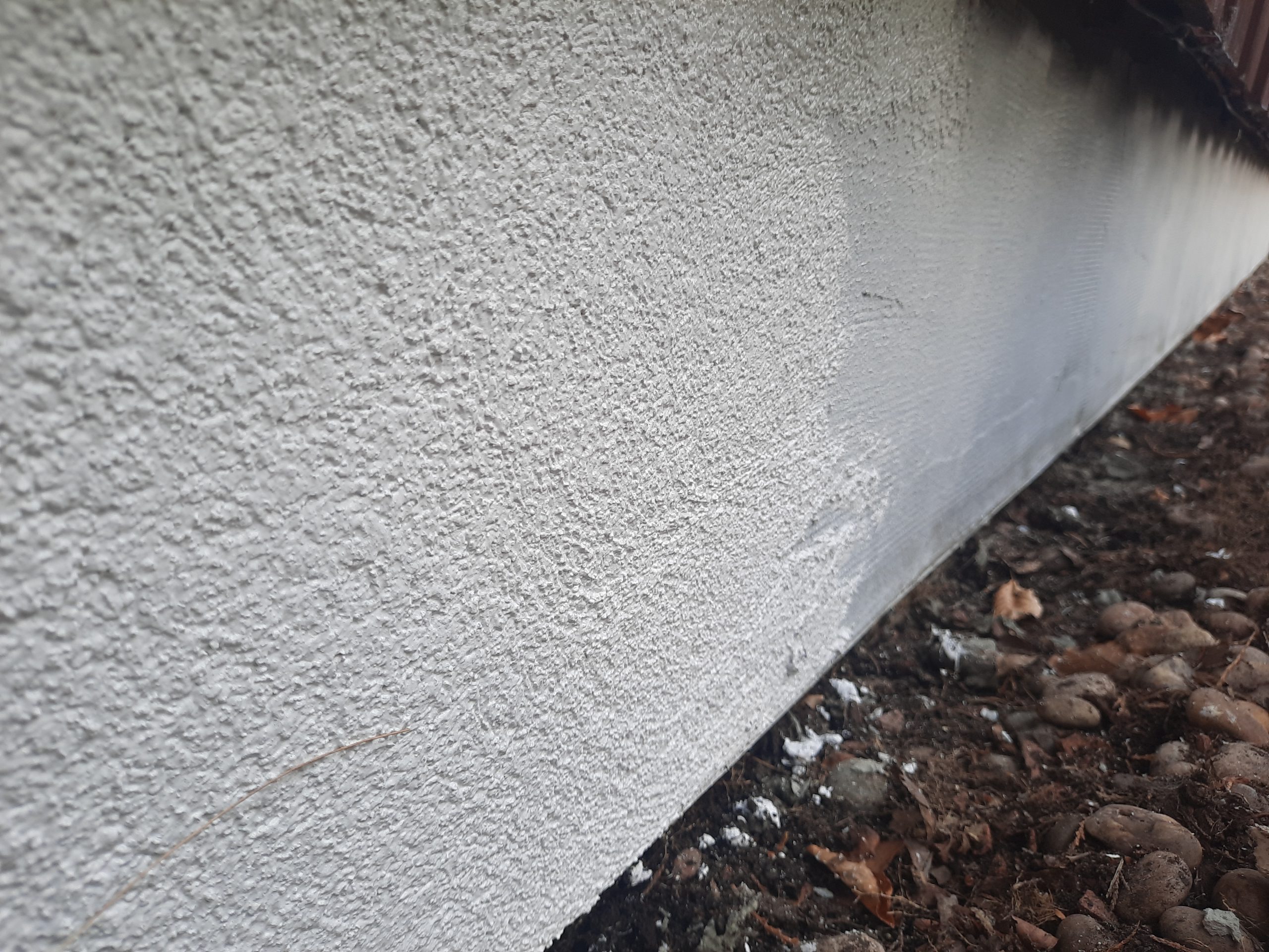 roughcast render repair on textured exterior wall