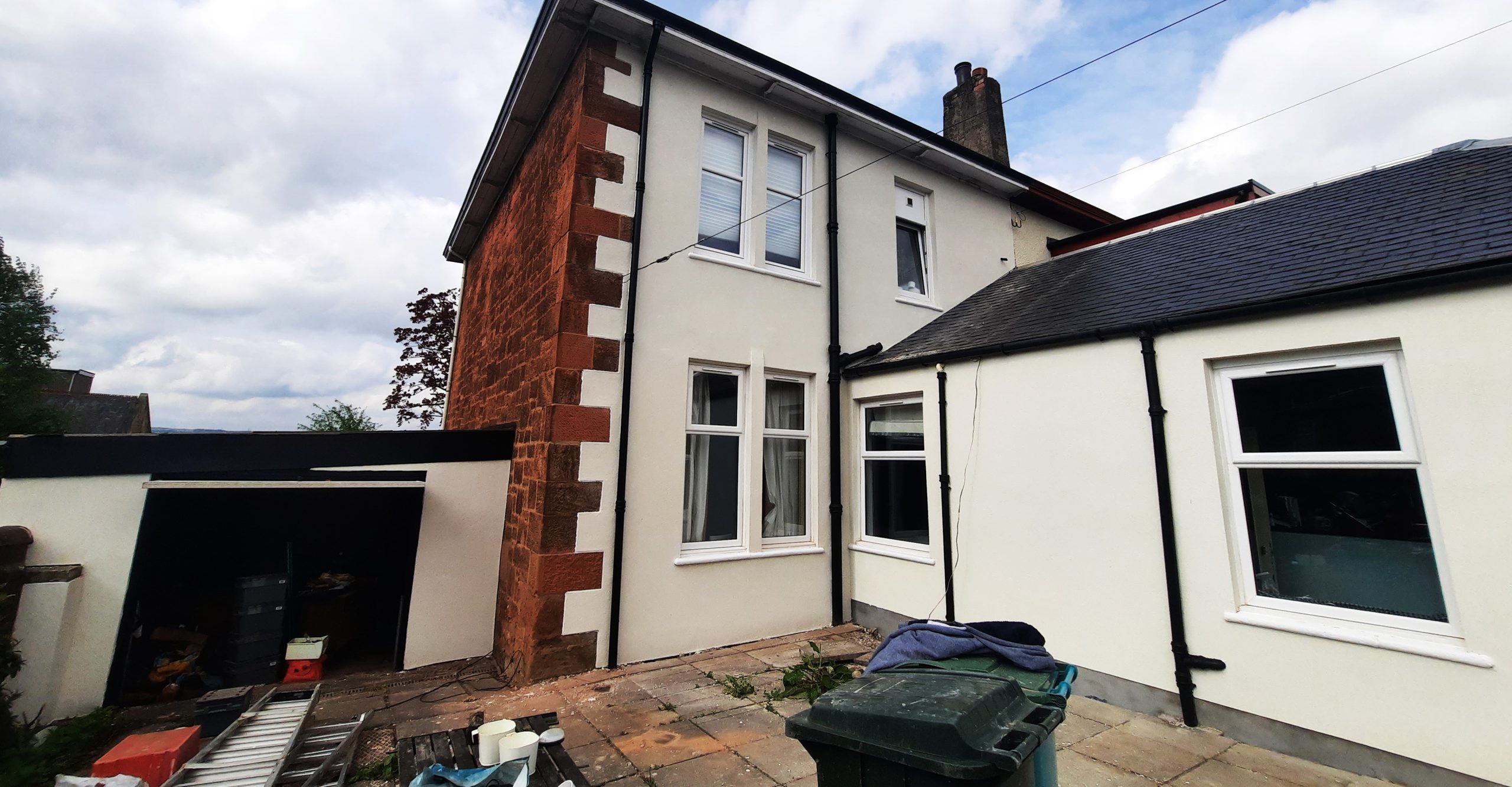 roughcast render repair on tall white side elevation