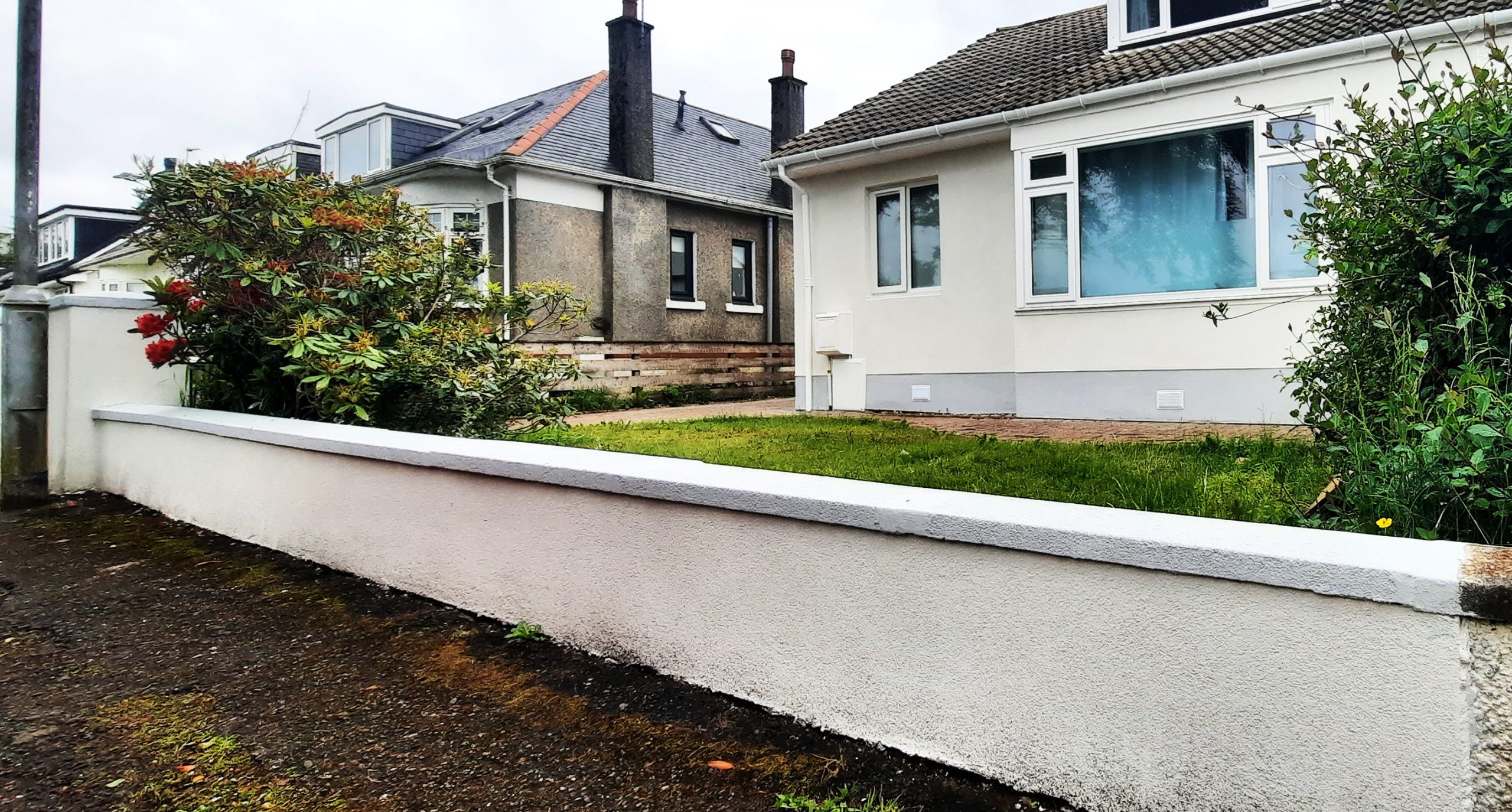 roughcast render repair on low boundary wall in garden