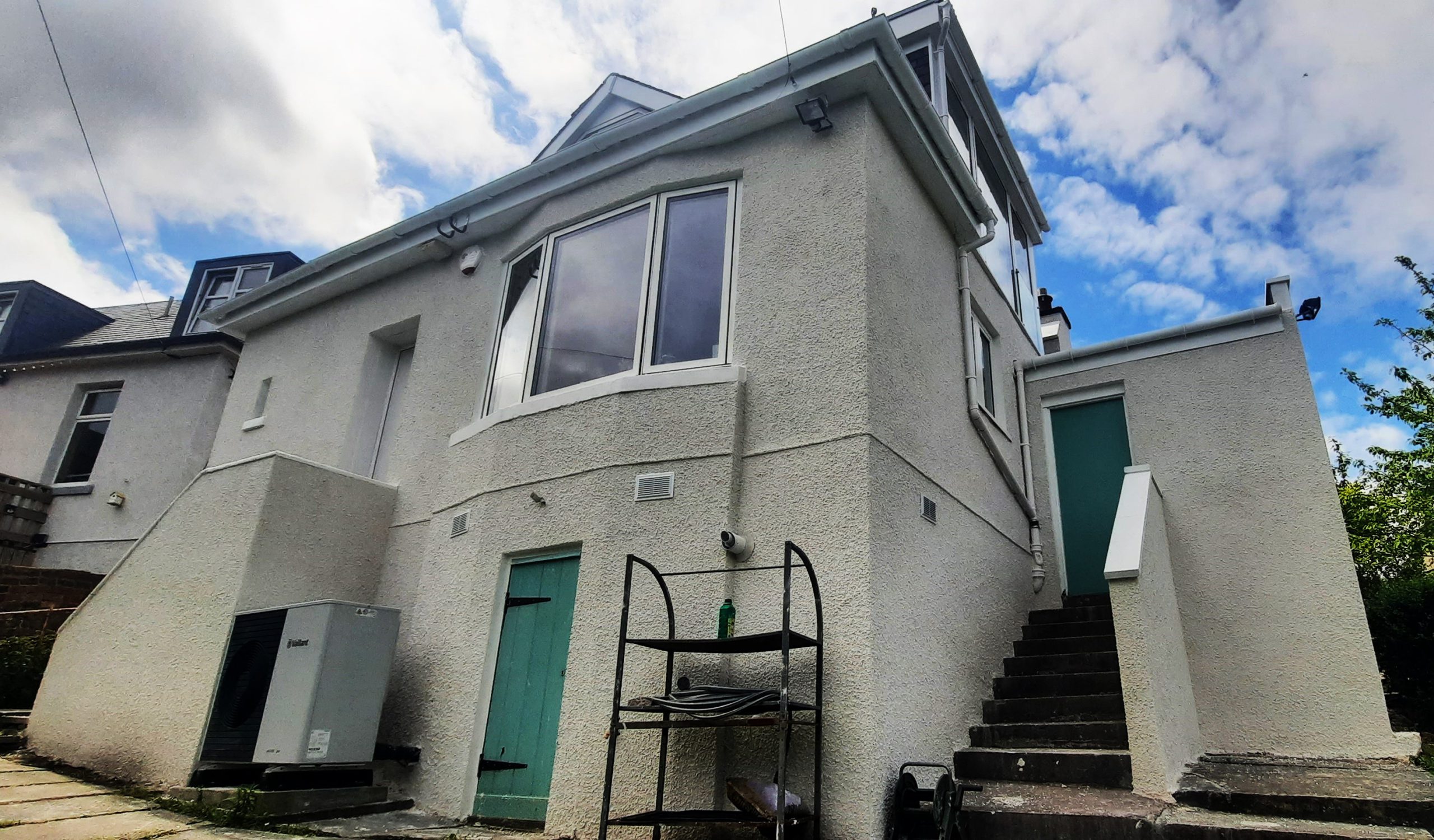 roughcast render repair on mixed-height wall section