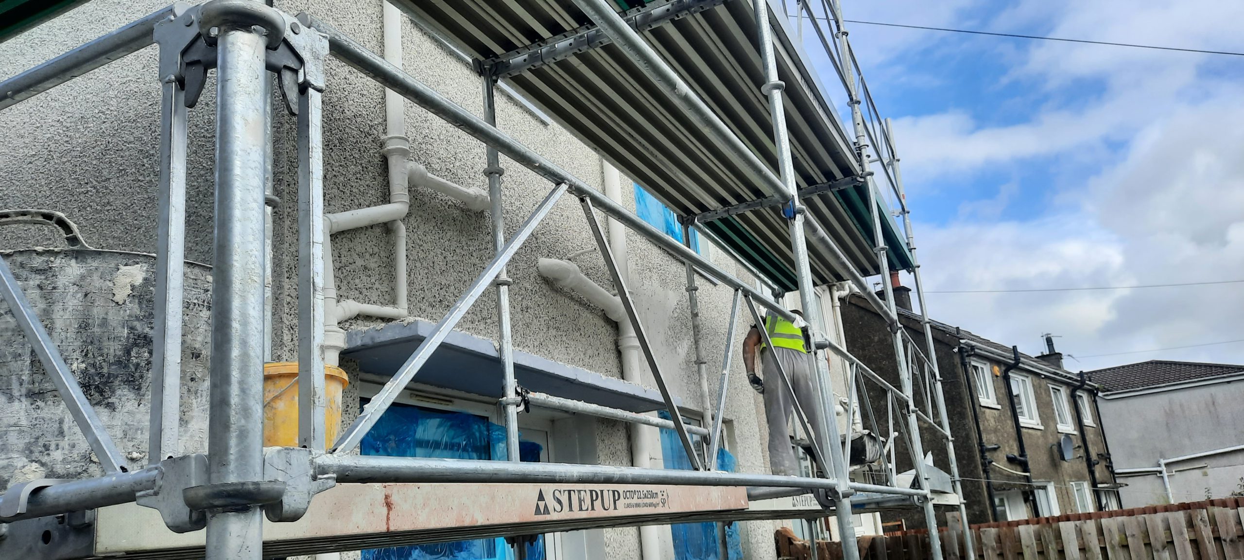 roughcast render repair on upper storey under scaffolding