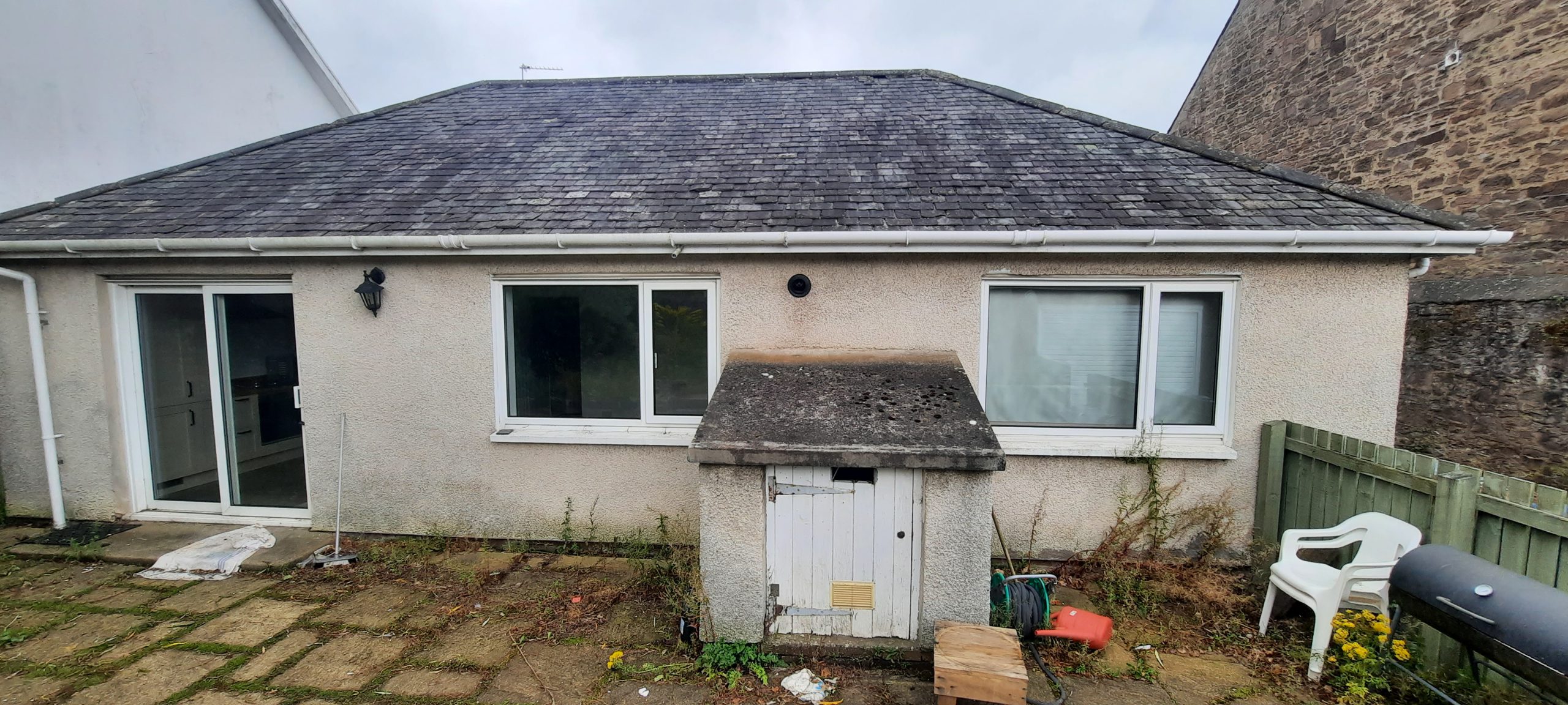 roughcast render repair above small outhouse door