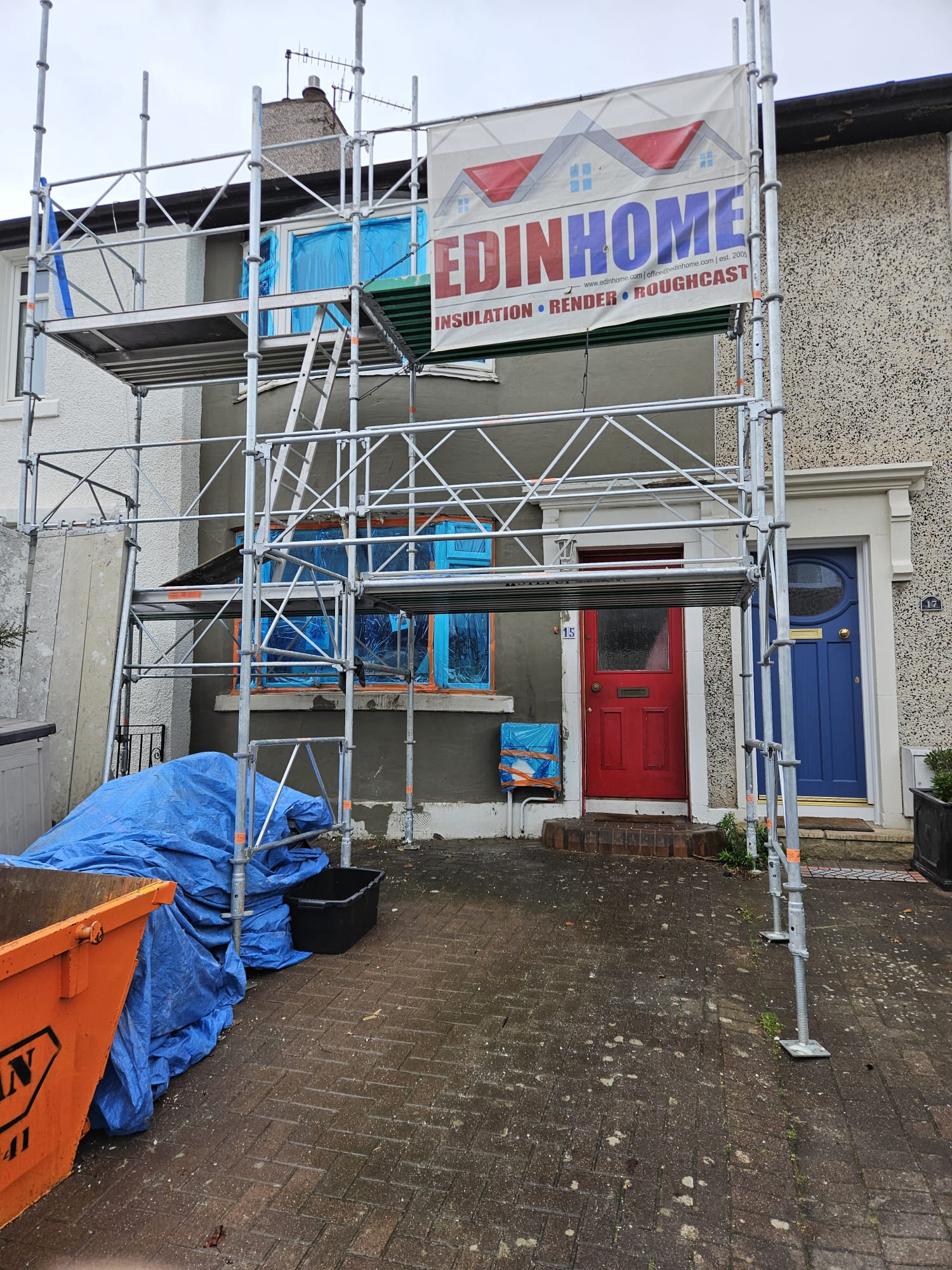roughcast render repair on scaffolded entryway