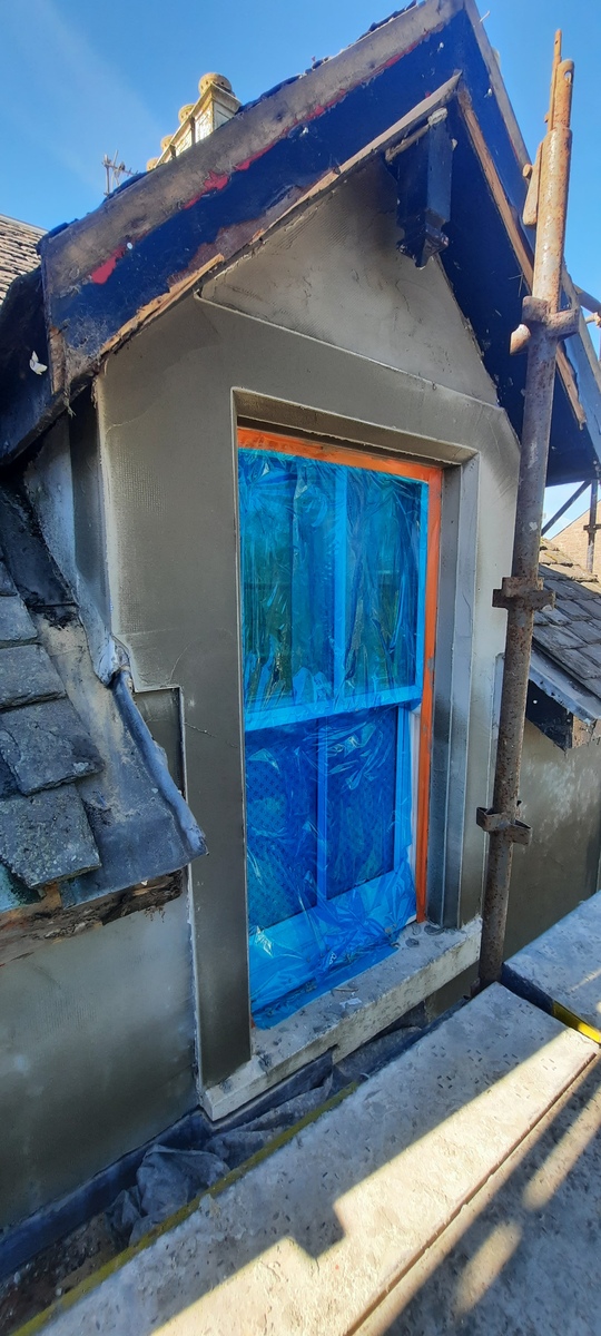 roughcast render repair around small dormer window