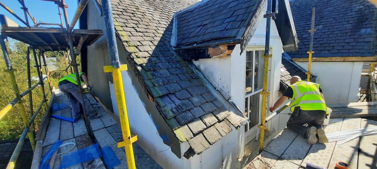 roughcaster Edinburgh restoring dormer wall beside roof tiles