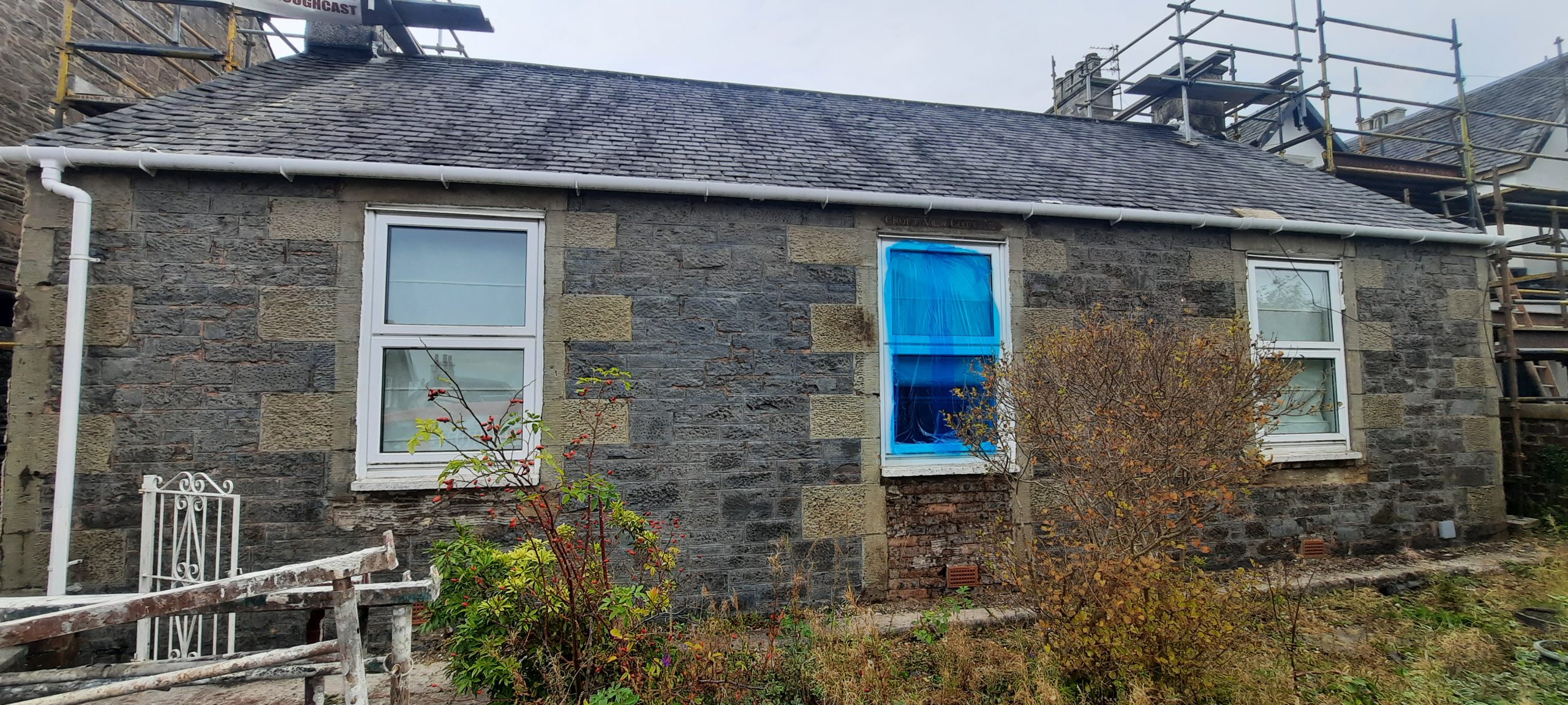 house rendering Edinburgh beside stone wall section