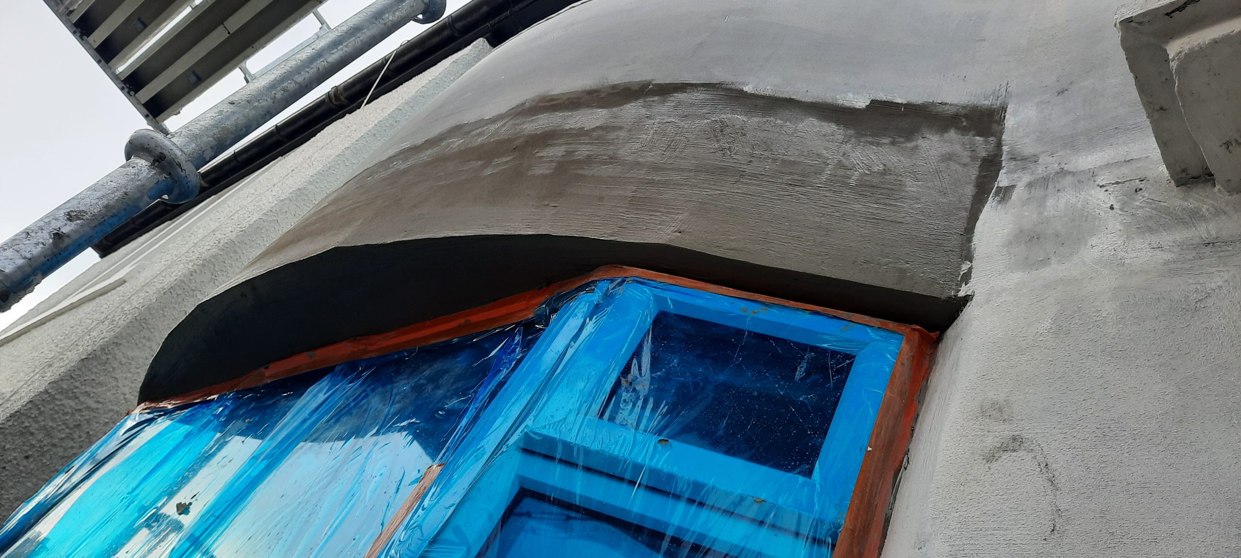 roughcasting Edinburgh applied above blue-protected windows