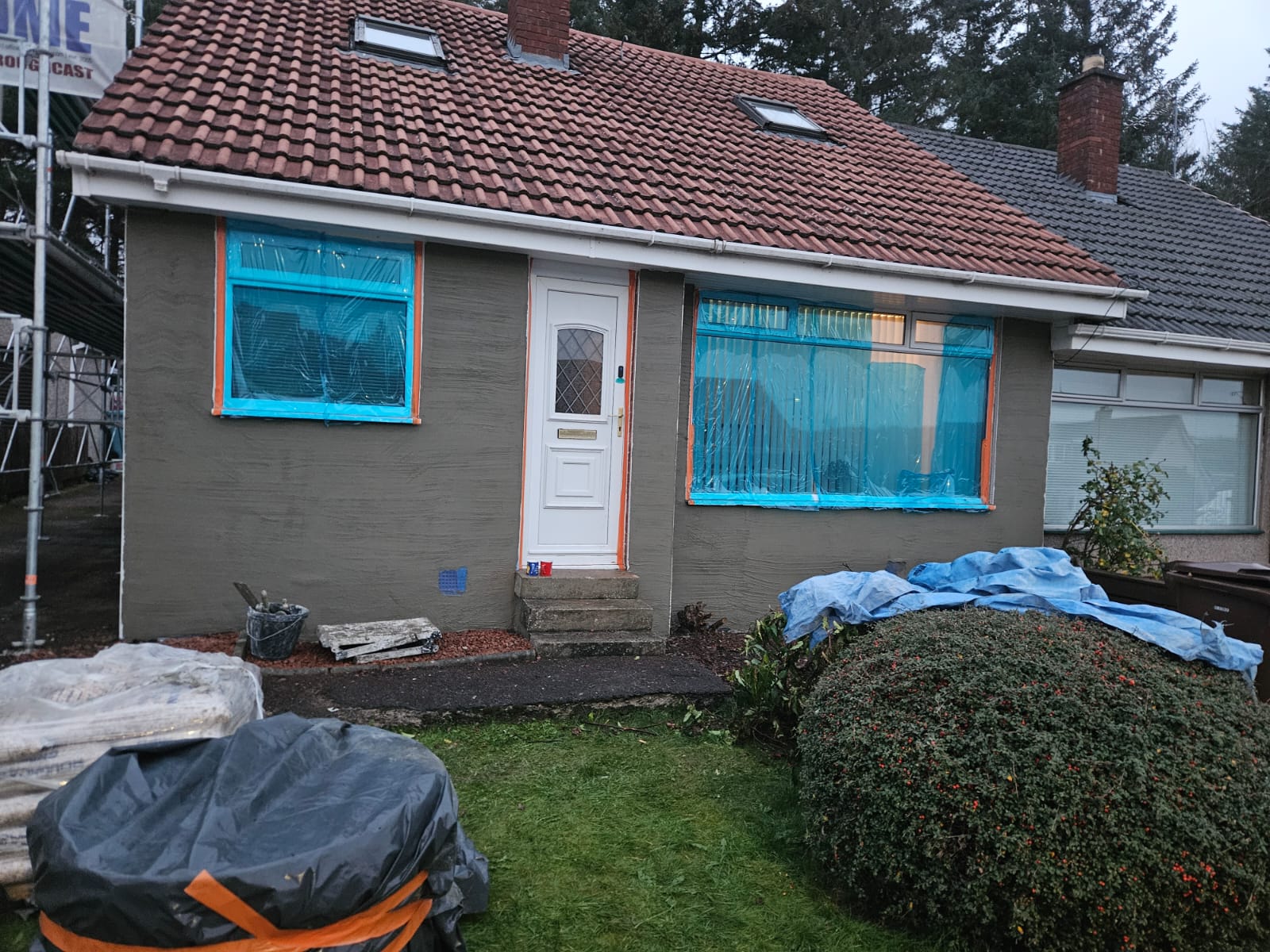 roughcast render repair on front wall with bushes