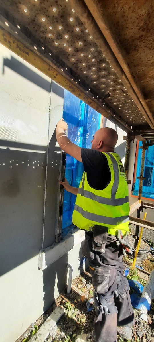 house rendering Edinburgh with worker fitting exterior boards