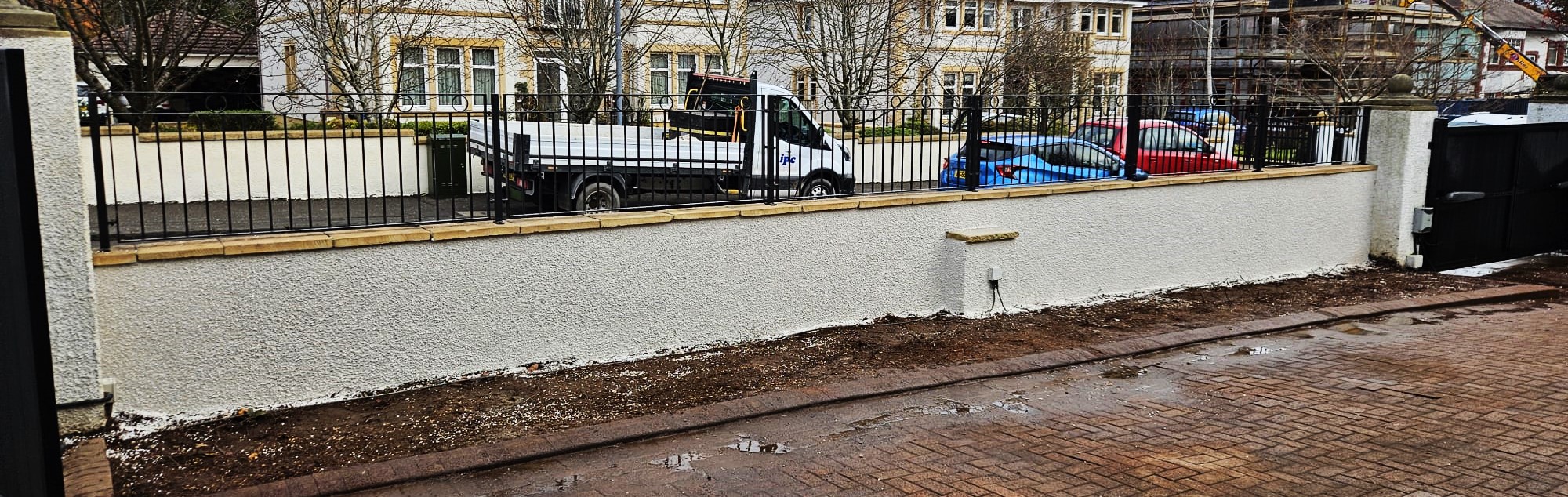 roughcast render repair along low boundary wall