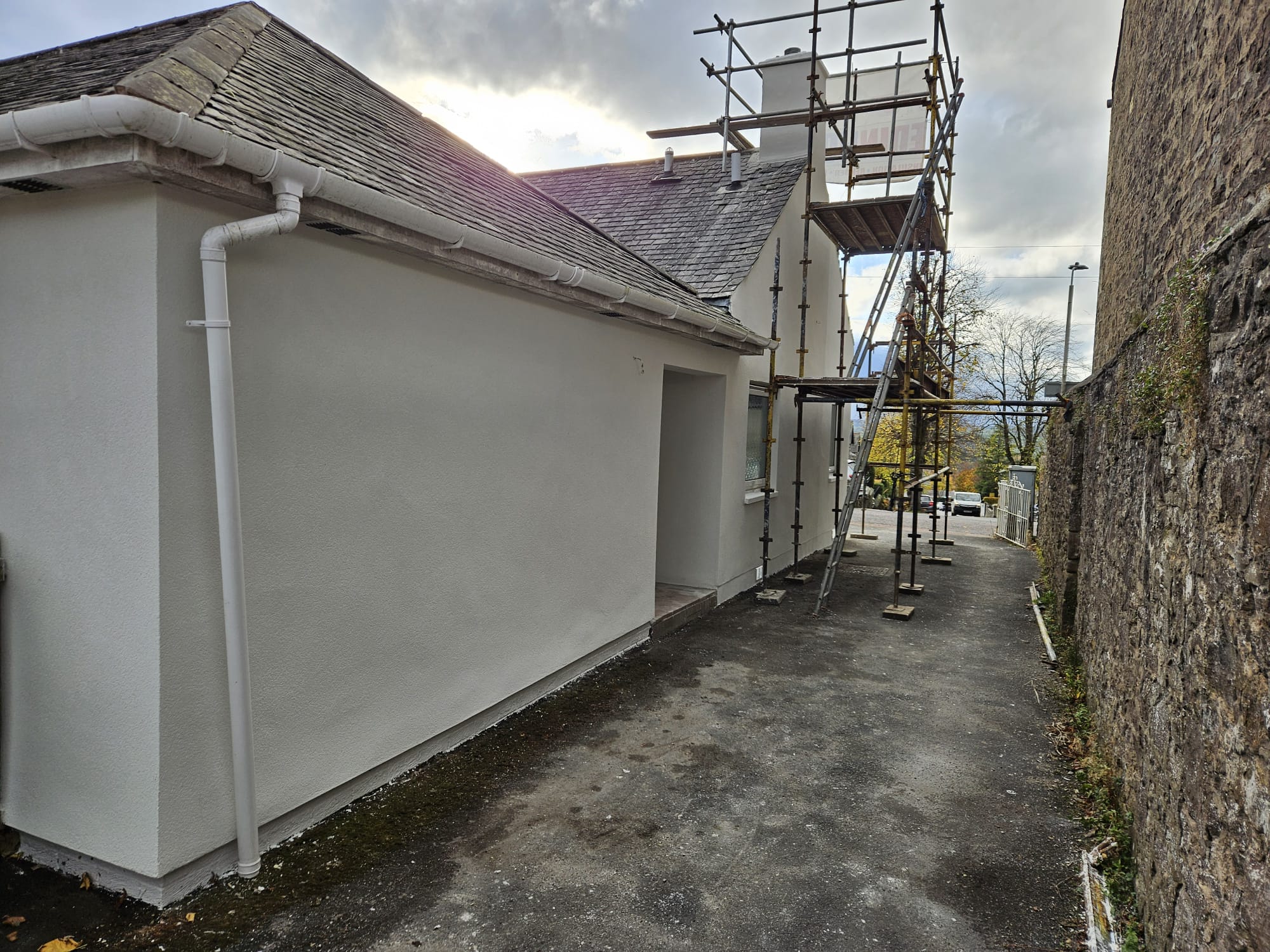 roughcast render repair along narrow side passage