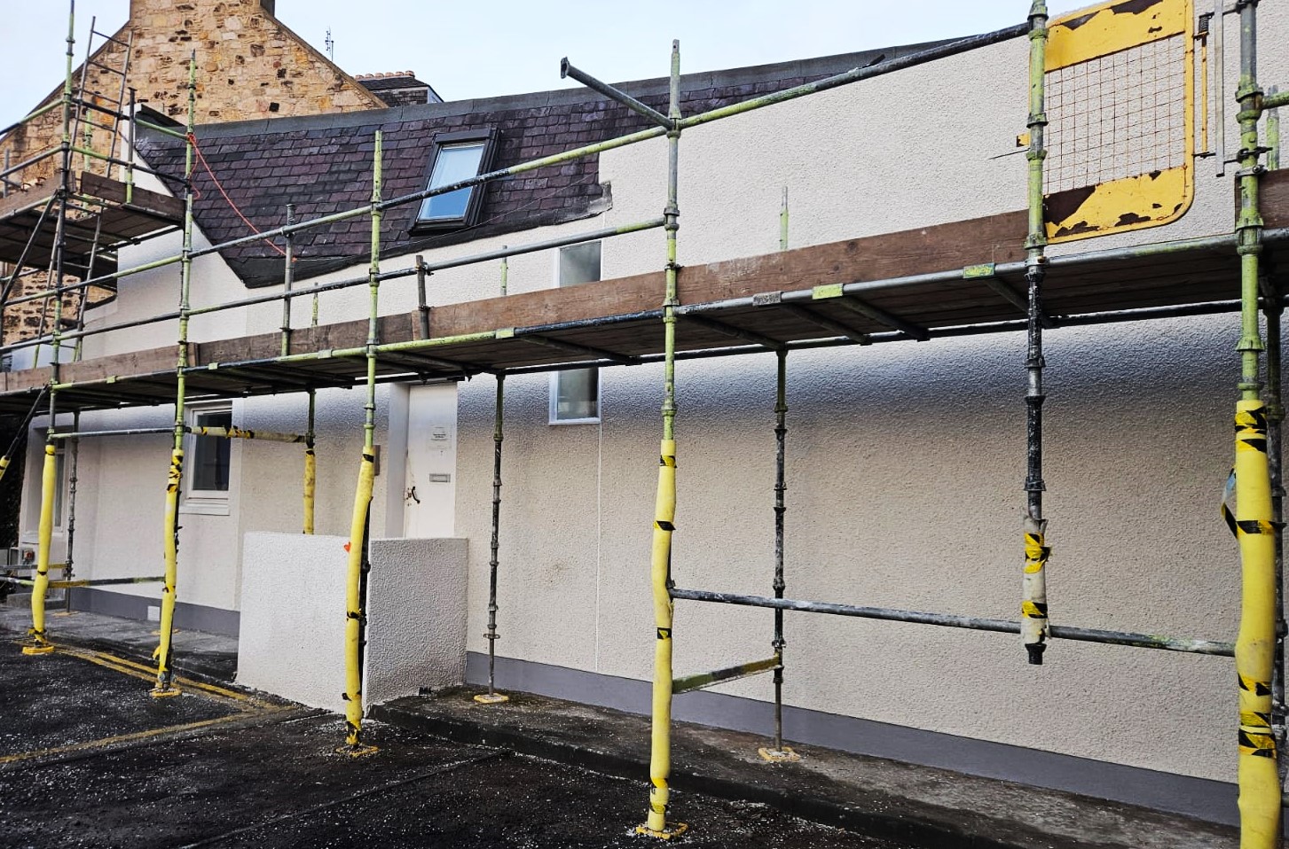 roughcaster Edinburgh working near upper scaffolding line